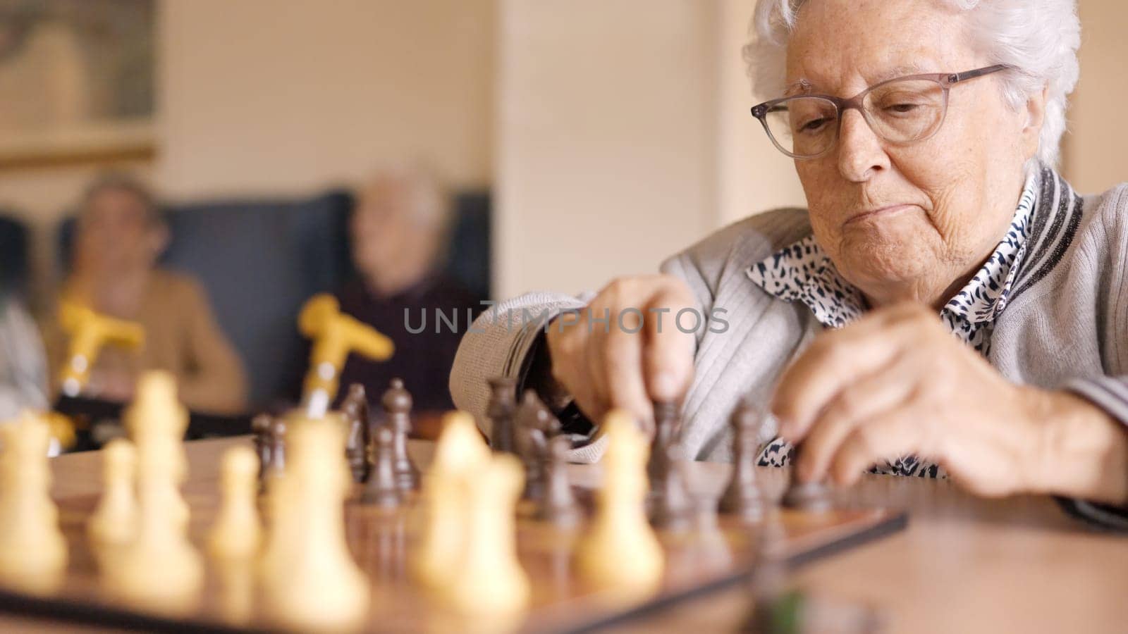 Two senior friends playing chess board game in geriatric by ivanmoreno