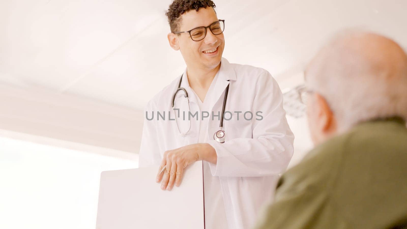 Doctor smiling kindly at an older man in a hospital