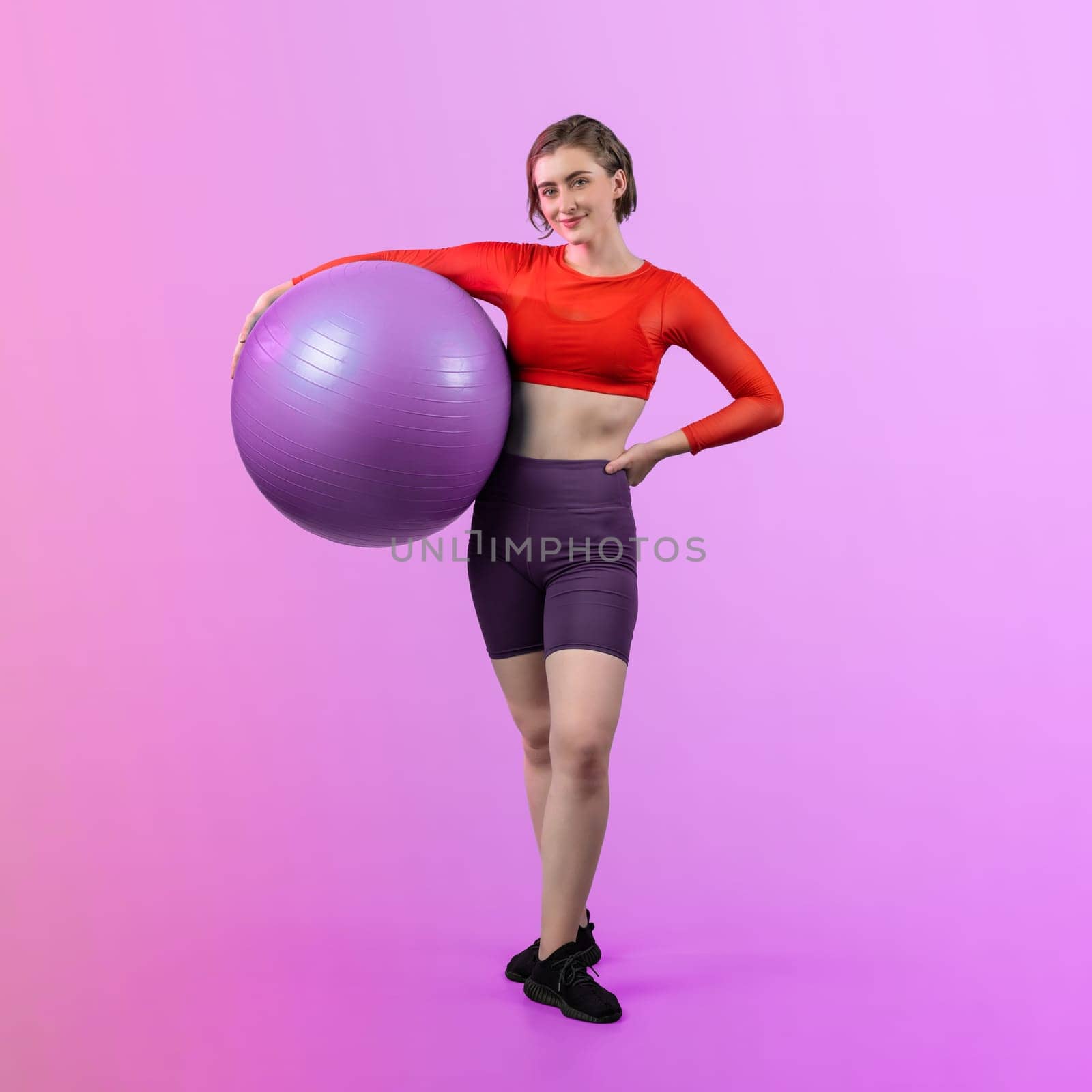 Full body length gaiety shot athletic and sporty young woman with fitness exercising ball in standing posture on isolated background. Healthy active and body care lifestyle.