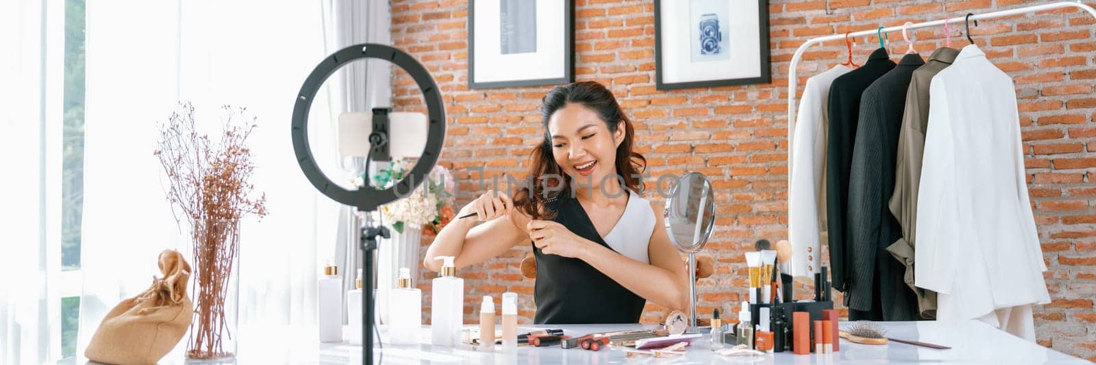 Woman influencer shoot live streaming vlog video review makeup uttermost social media or blog. Happy young girl with cosmetics studio lighting for marketing recording session broadcasting online.