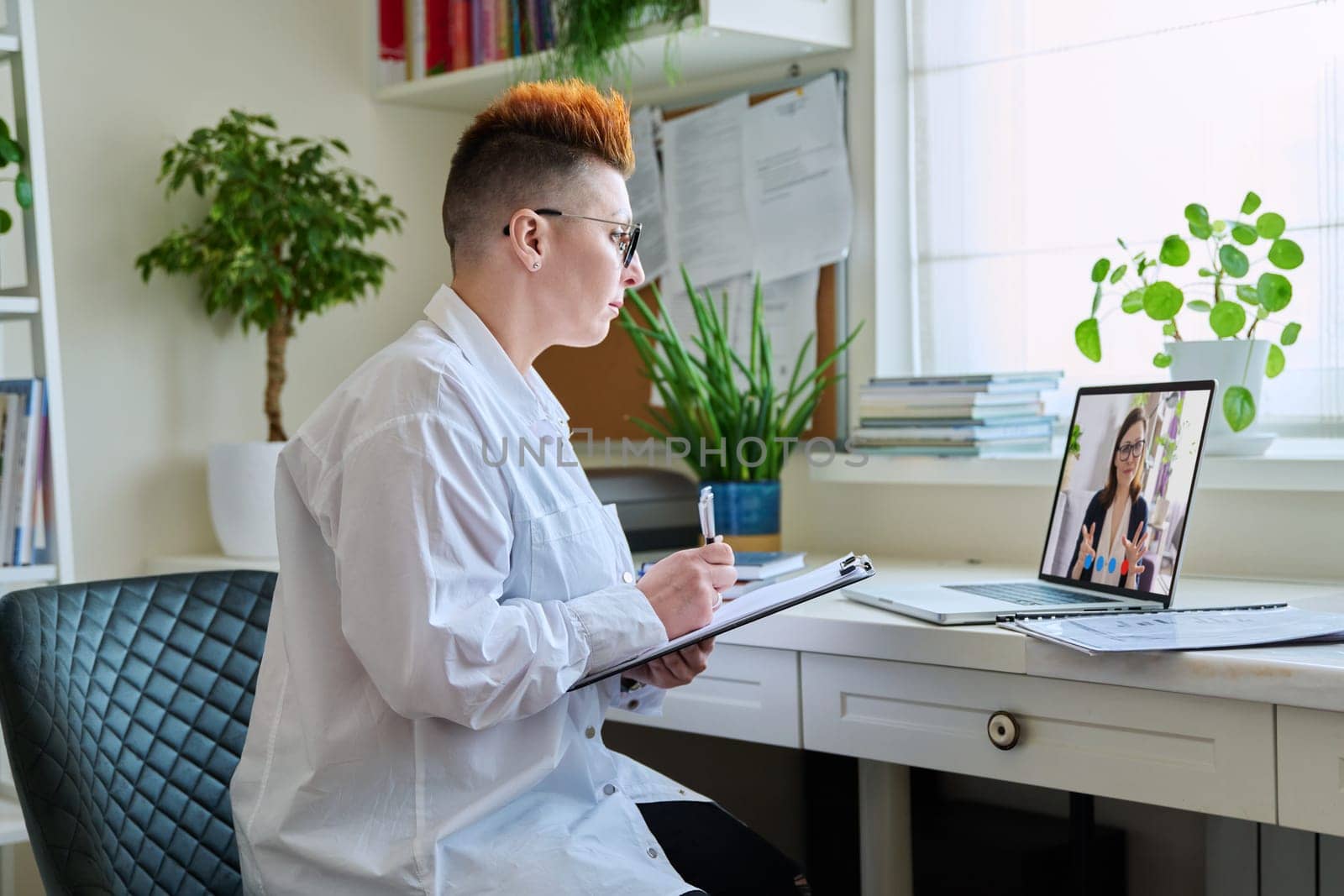 Female psychologist having online therapy with middle aged woman patient by VH-studio