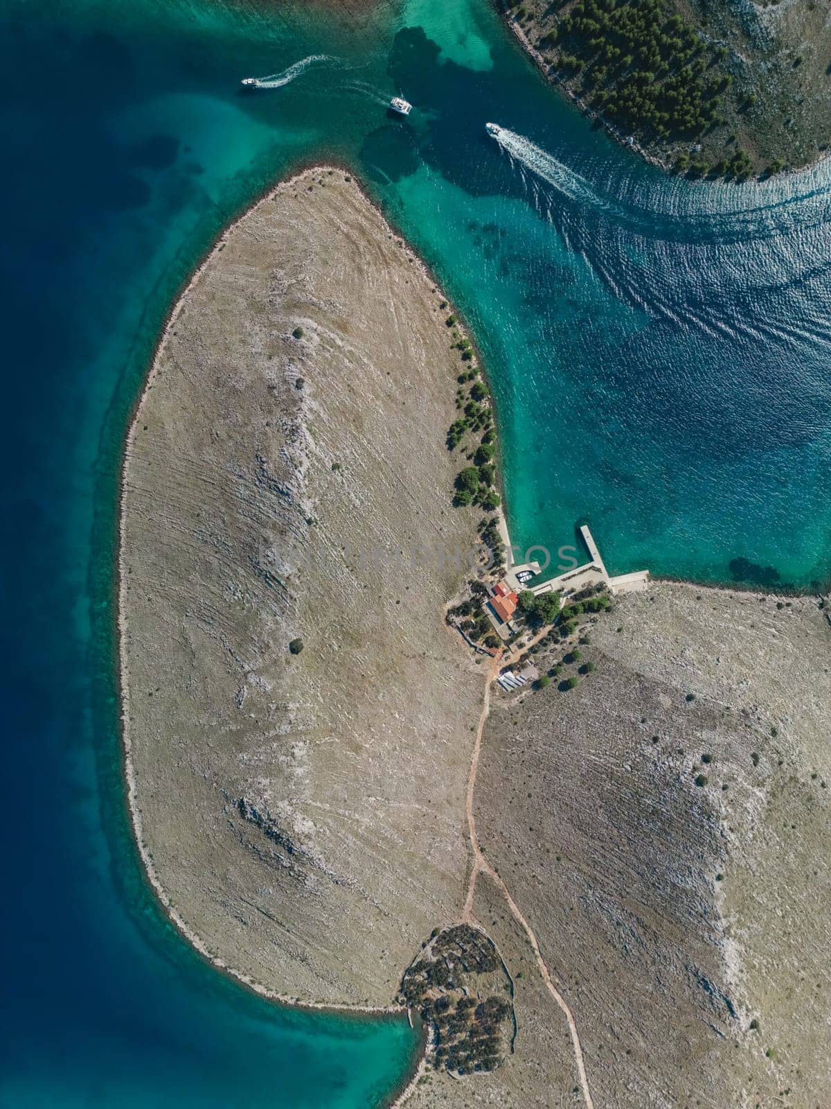 Drone view directly from above on island of Kornati archipelago with small houses and pier for boats, Croatia