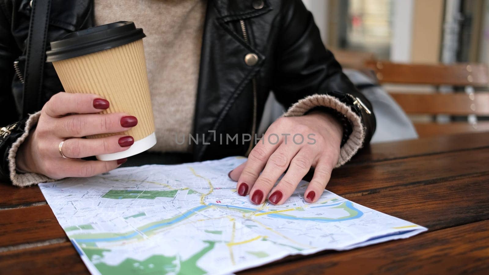 Stylish Female Tourist Checks City Sightseeing Route On Map While Sipping Coffee In Street Cafe