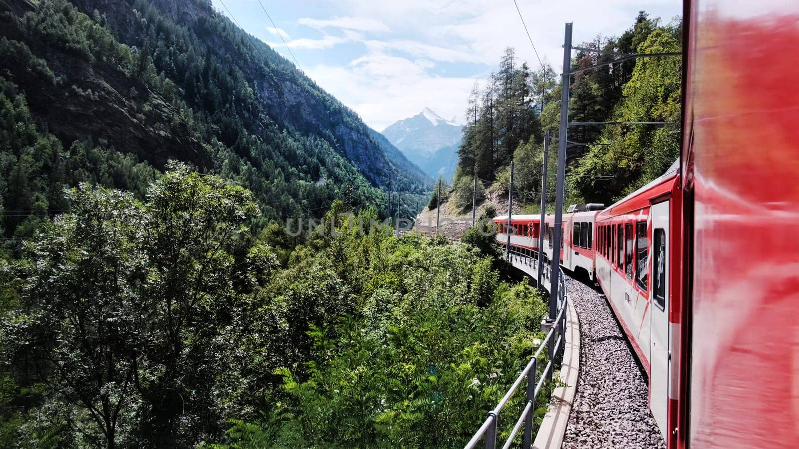 Red Swiss Train Moving By Valley In Mountains by GekaSkr