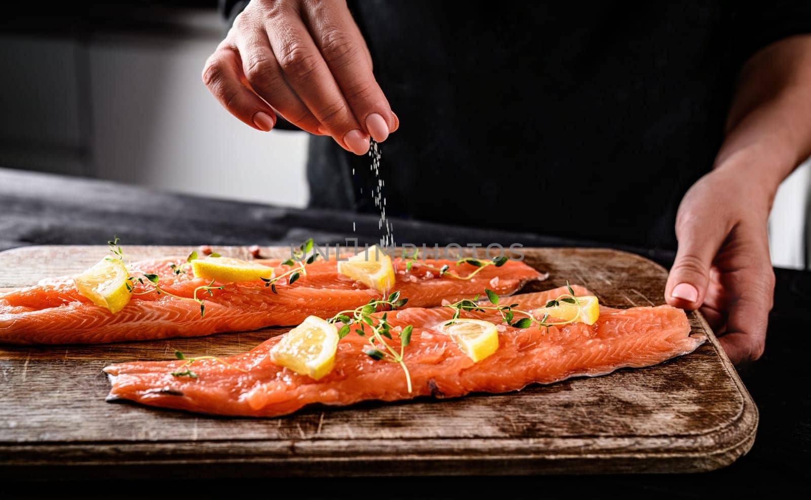 Chief Salting With A Pinch Of Salt Raw Red Trout Fish For Cooking At Kitchen