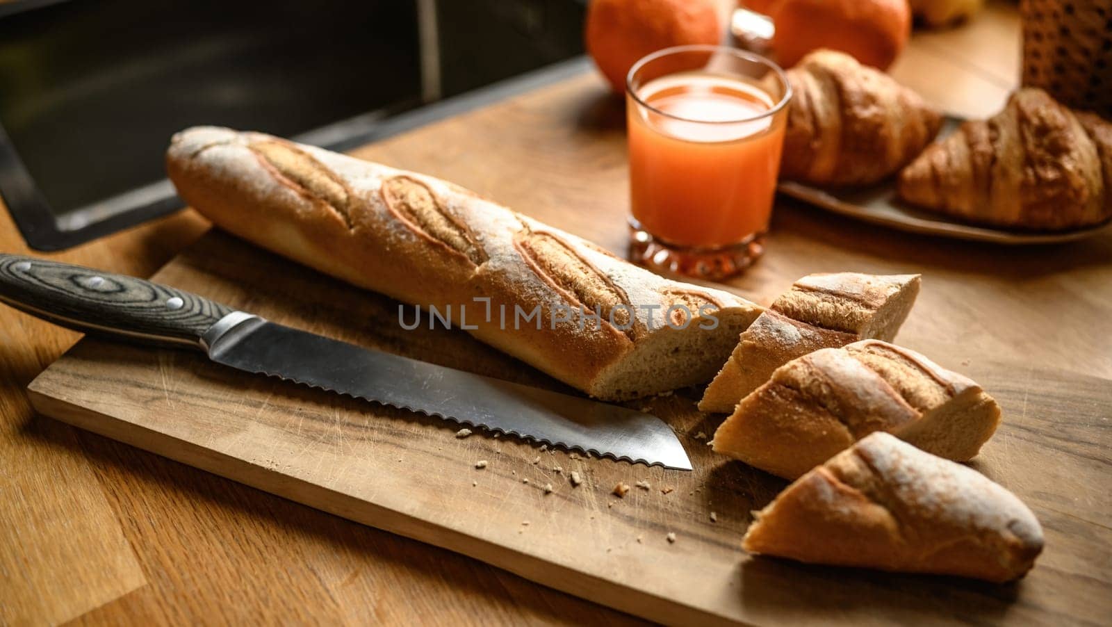 Fresh baguette on a cutting board at the kitchen by GekaSkr