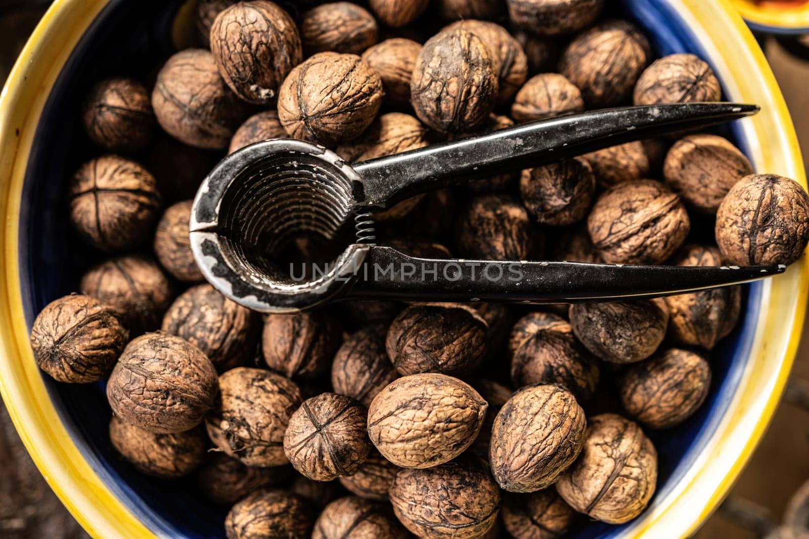 Walnuts and nutcracker in bowl closeup. Deicious nuts for vegan heathy protein diet and nutrition