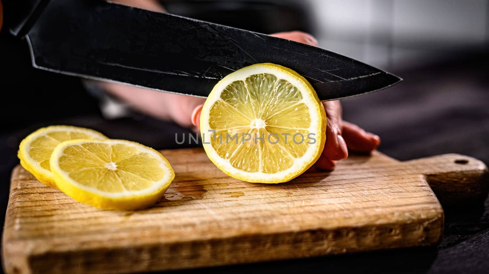Girl hand cutting lemon with knife closeup by GekaSkr