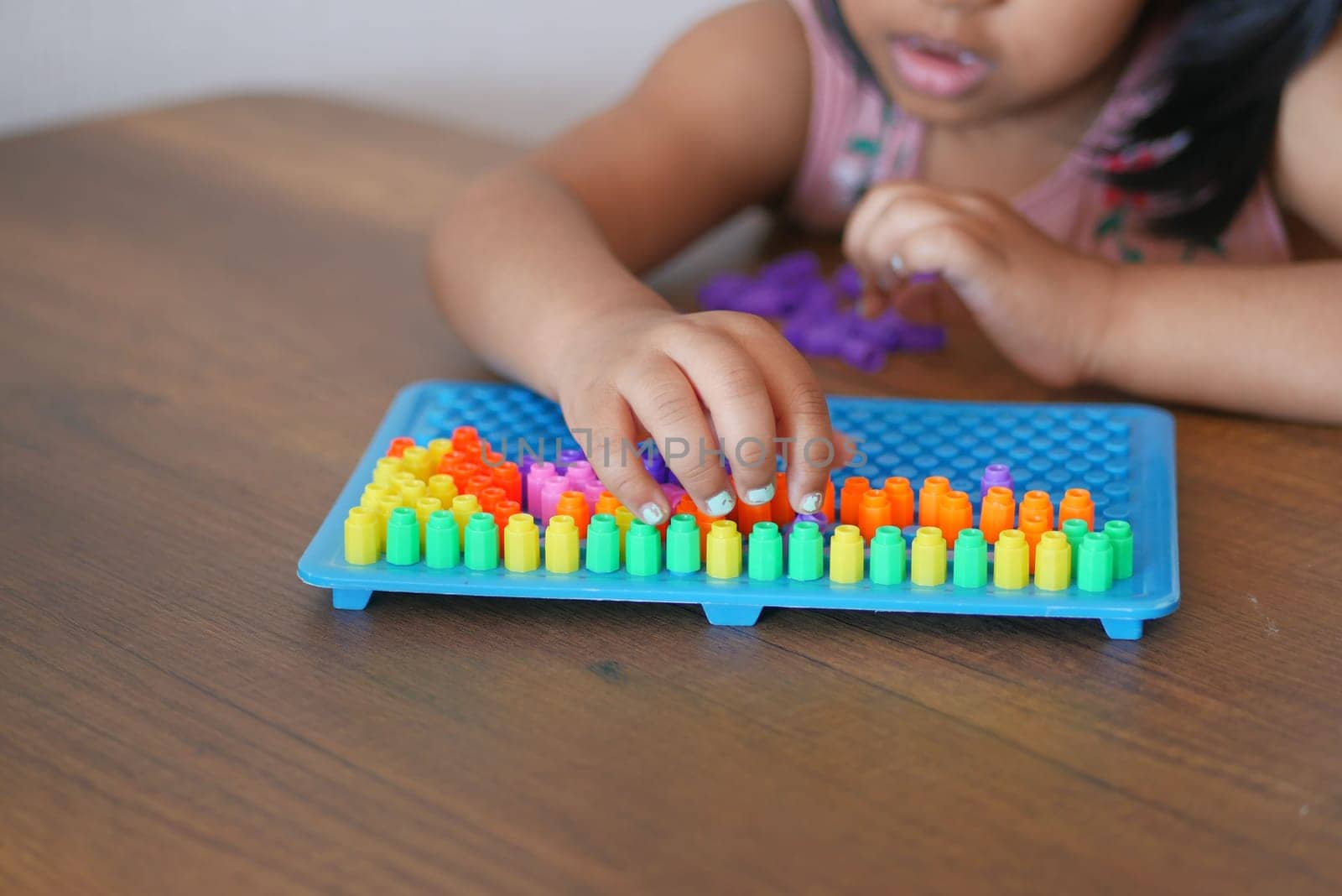 A little girl plays a game, developing motor skills and thinking .