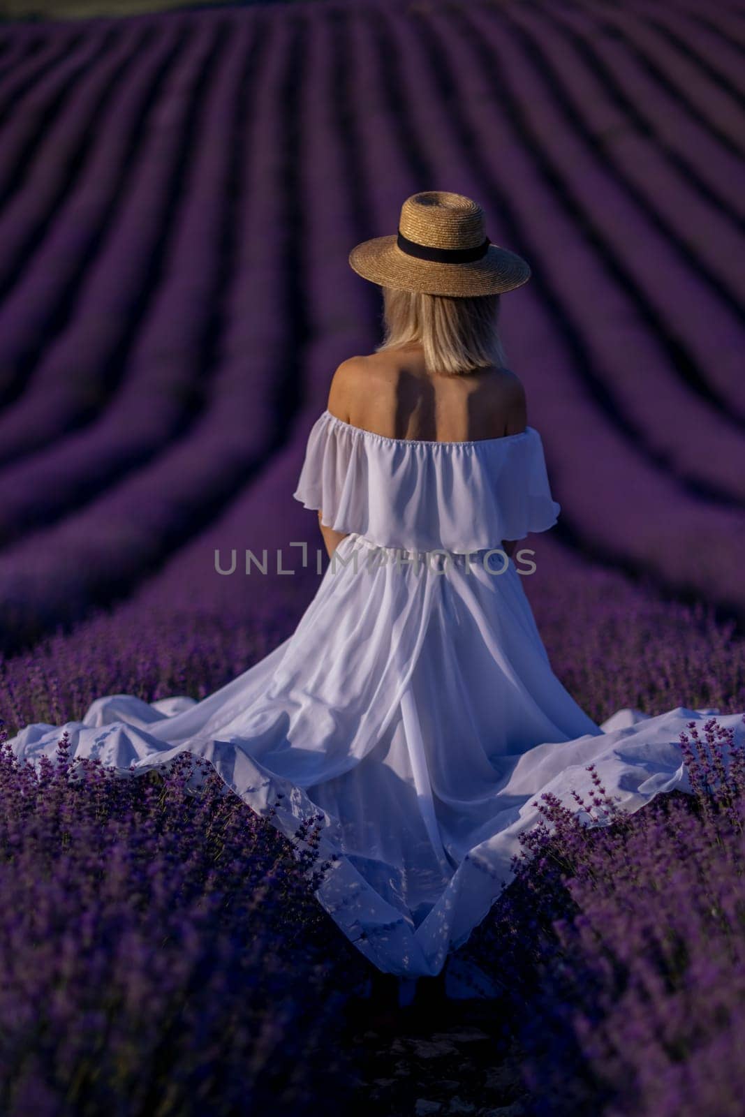Back view woman lavender sunset. Happy woman in white dress holds lavender bouquet. Aromatherapy concept, lavender oil, photo session in lavender by Matiunina