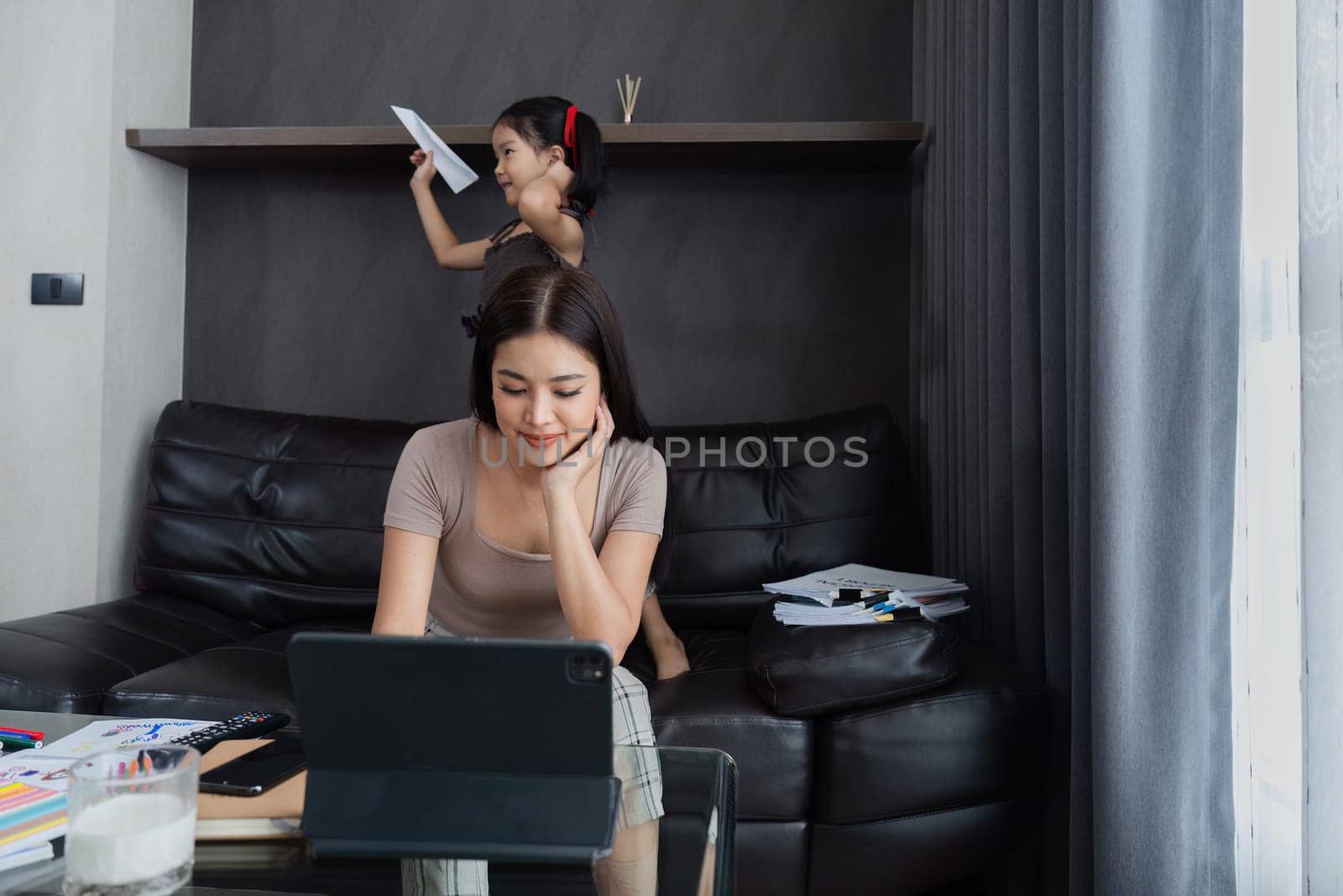 business woman work from home and take care of her child while working, doing activities with her child while working by itchaznong