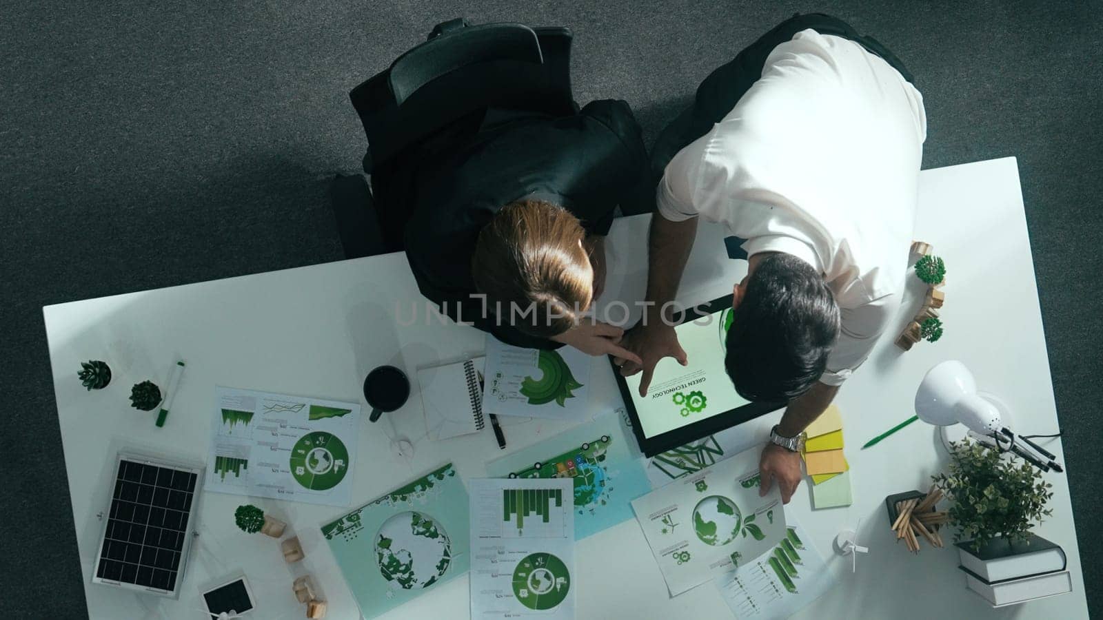 Top down view of business man presenting sustainable idea to manager by using tablet display ESG environmental social governance. Manager working together planning to use clean energy. Alimentation.