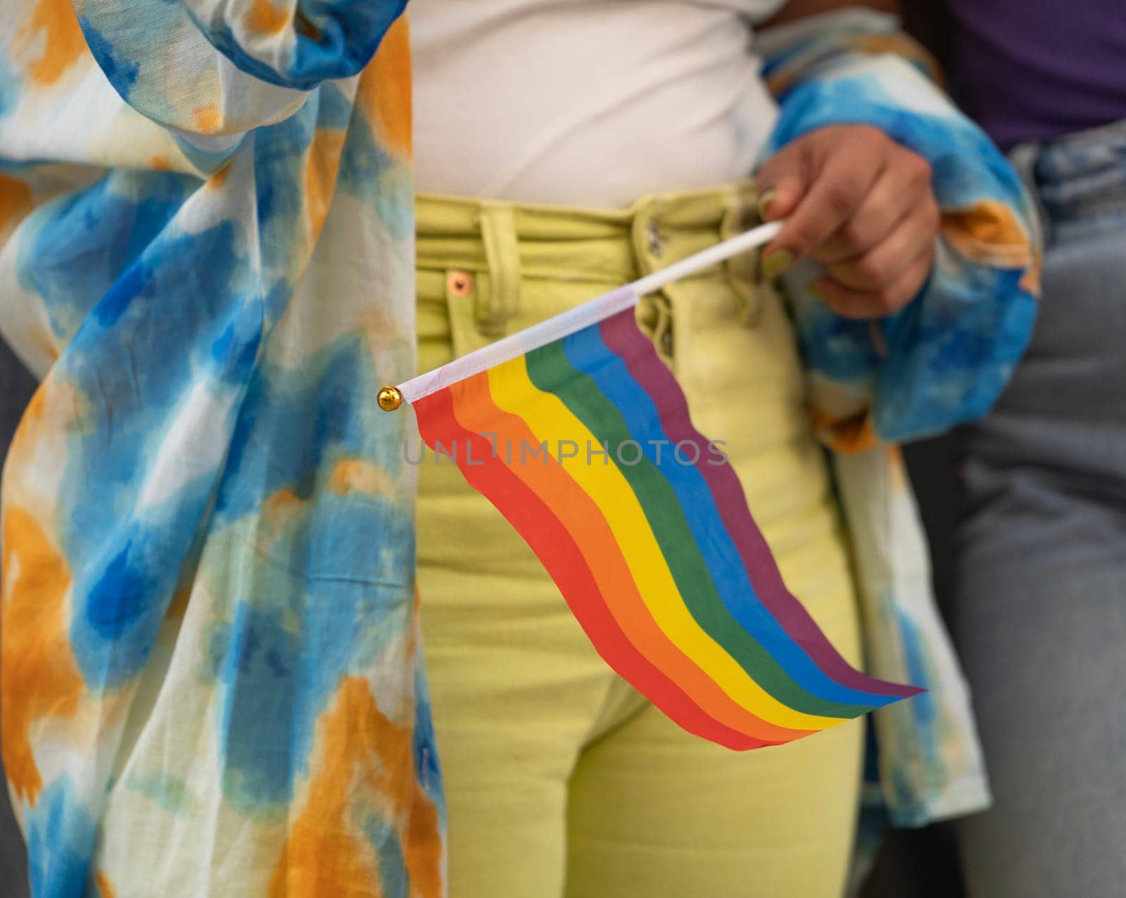 Close up of lesbian woman holding a rainbow flag for the gay parade.