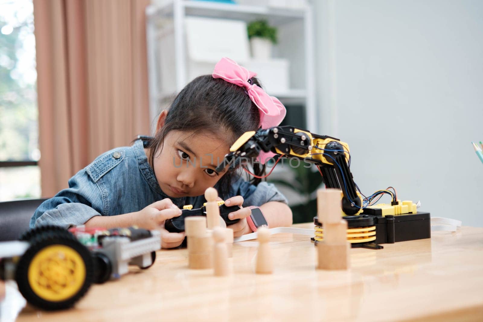 A young girl is playing with a remote control a robot by ijeab