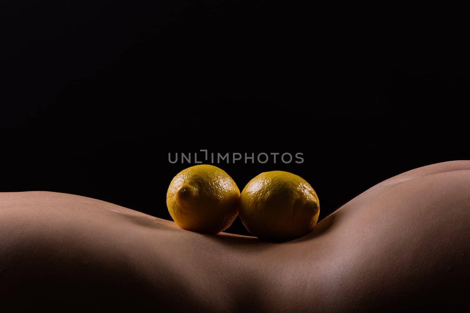 Lemon, natural vitamin c help skin whitening. Naked woman lying on her back with fruit located by Zelenin