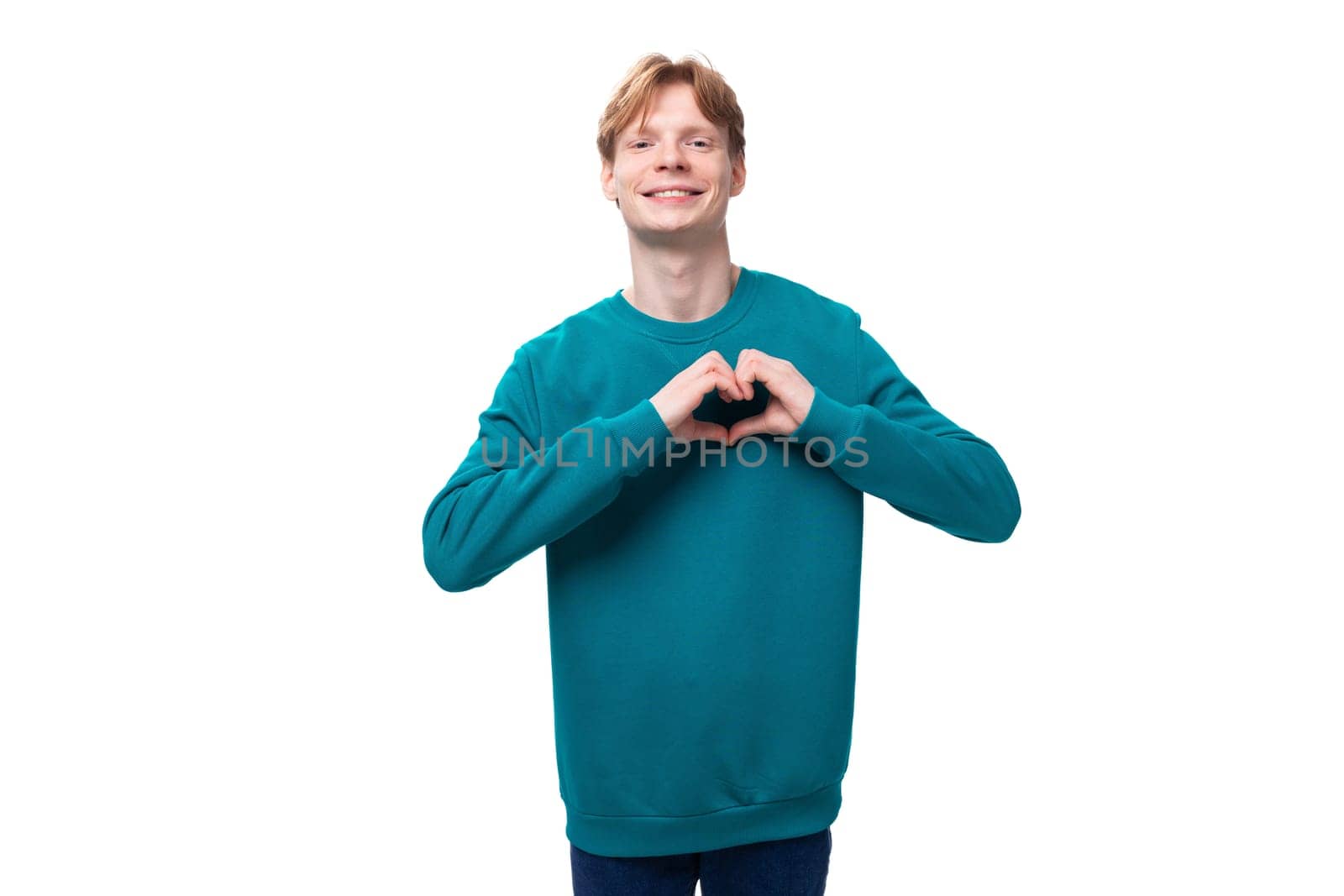 young happy man with red hair dressed in a blue sweater.