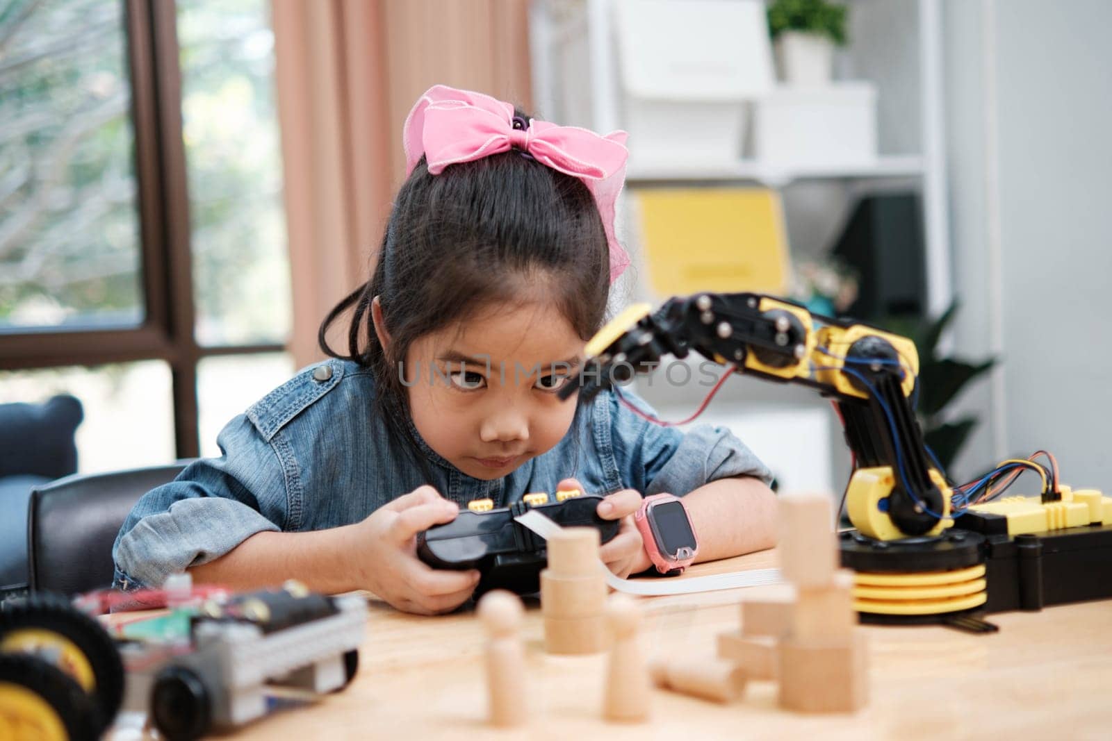 A young girl is playing with a remote control a robot by ijeab