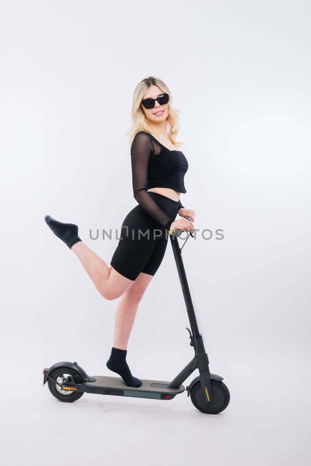 Happy young woman wear glasses riding electric scooter background studio People lifestyle concept