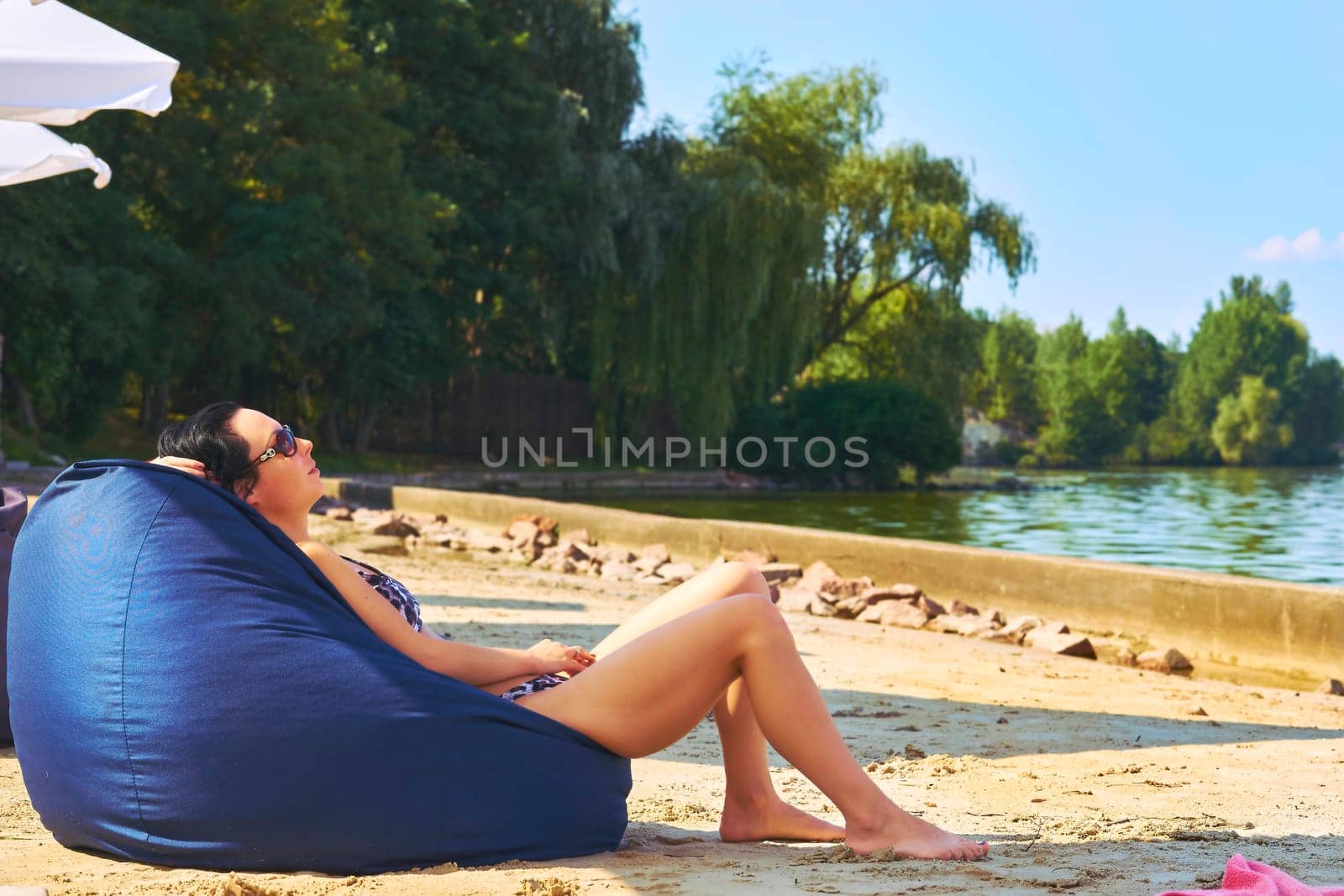 Rest,relaxation,summer beach. A woman takes a sunbath on an ottoman pillow by jovani68