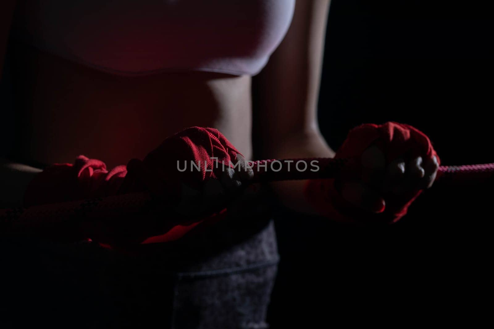 A tightly clenched hand on the boxing ring. A player strongly focused before her life fight .