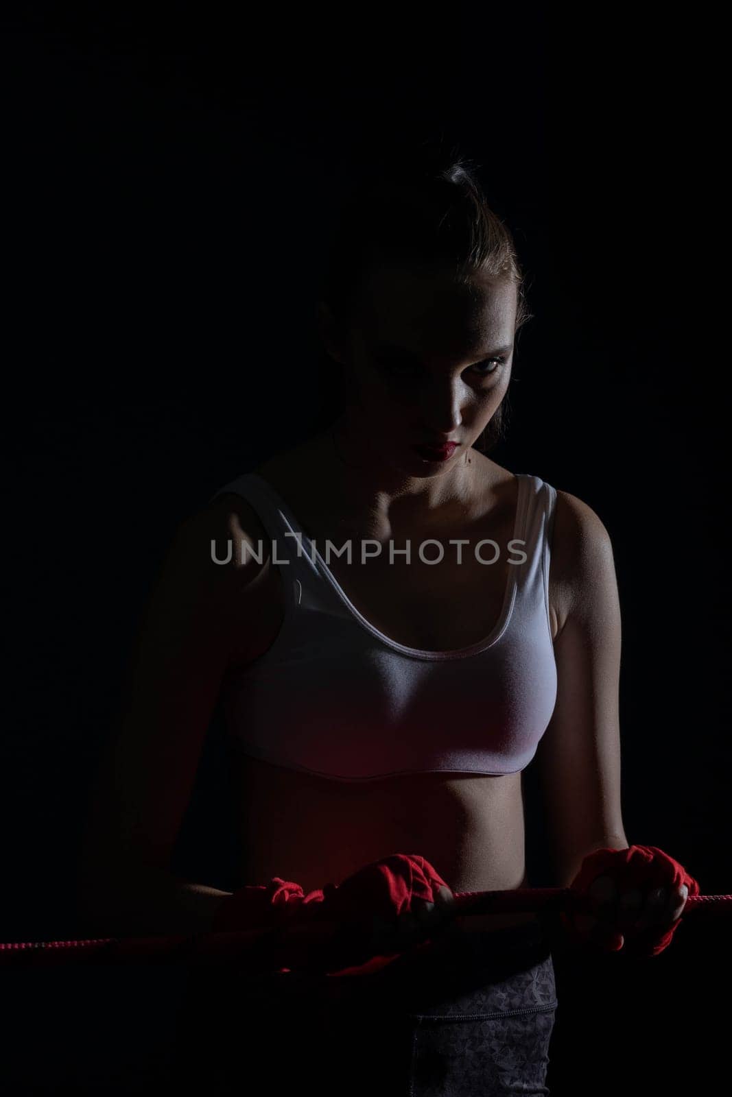 A tightly clenched hand on the boxing ring. A player strongly focused before her life fight .