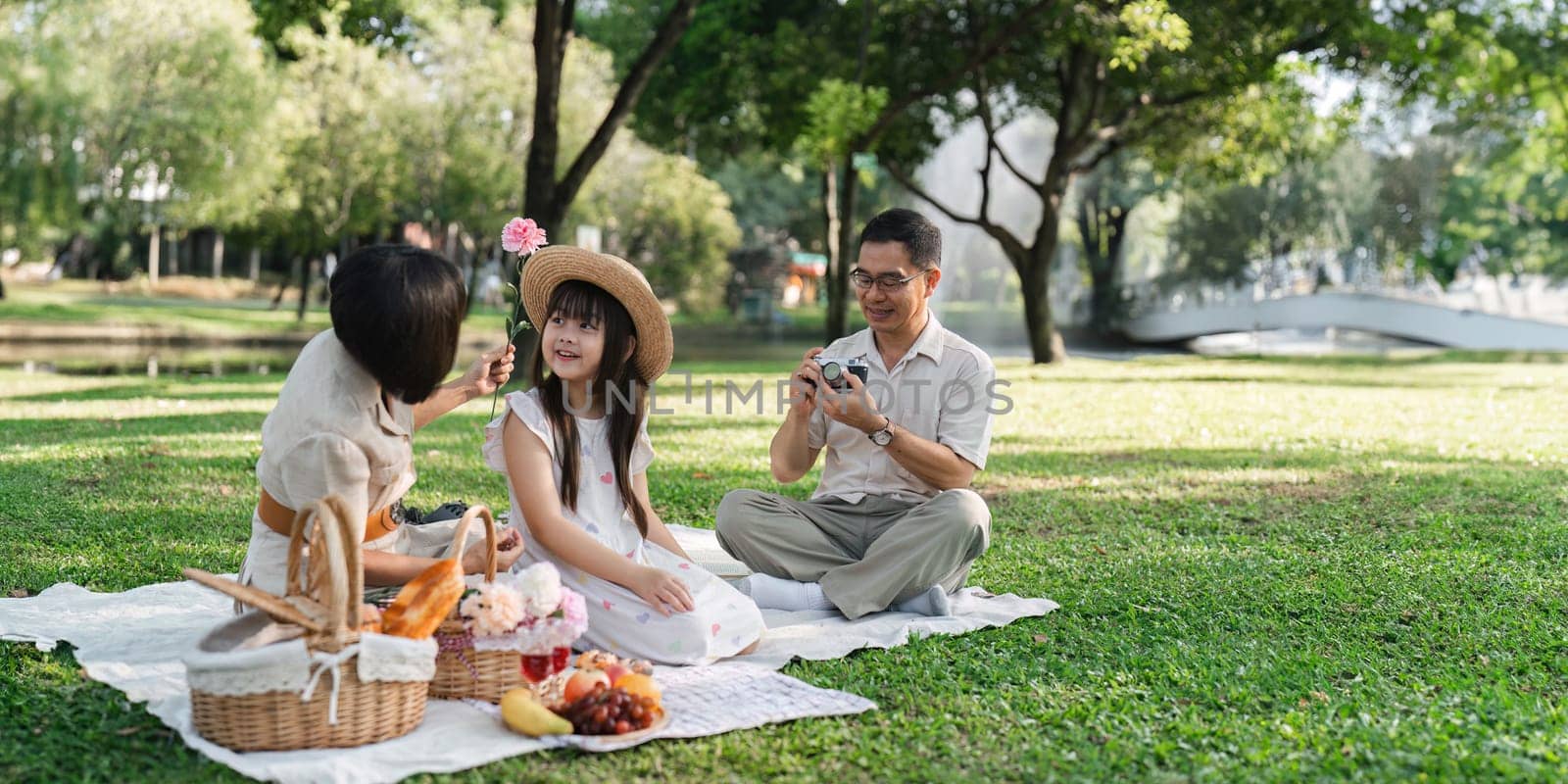 Family day, family picnic together at the park. Retired grandparent take granddaughter to relax and spend time together at the park by itchaznong