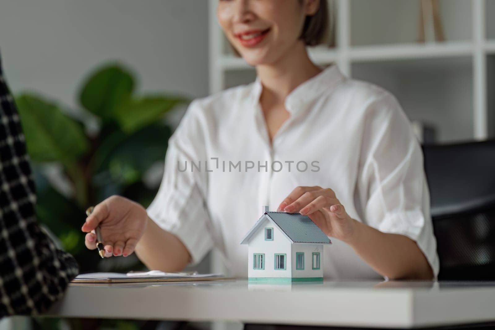 Real estate agent talked about the terms of the home purchase agreement and asked the customer to sign the documents.