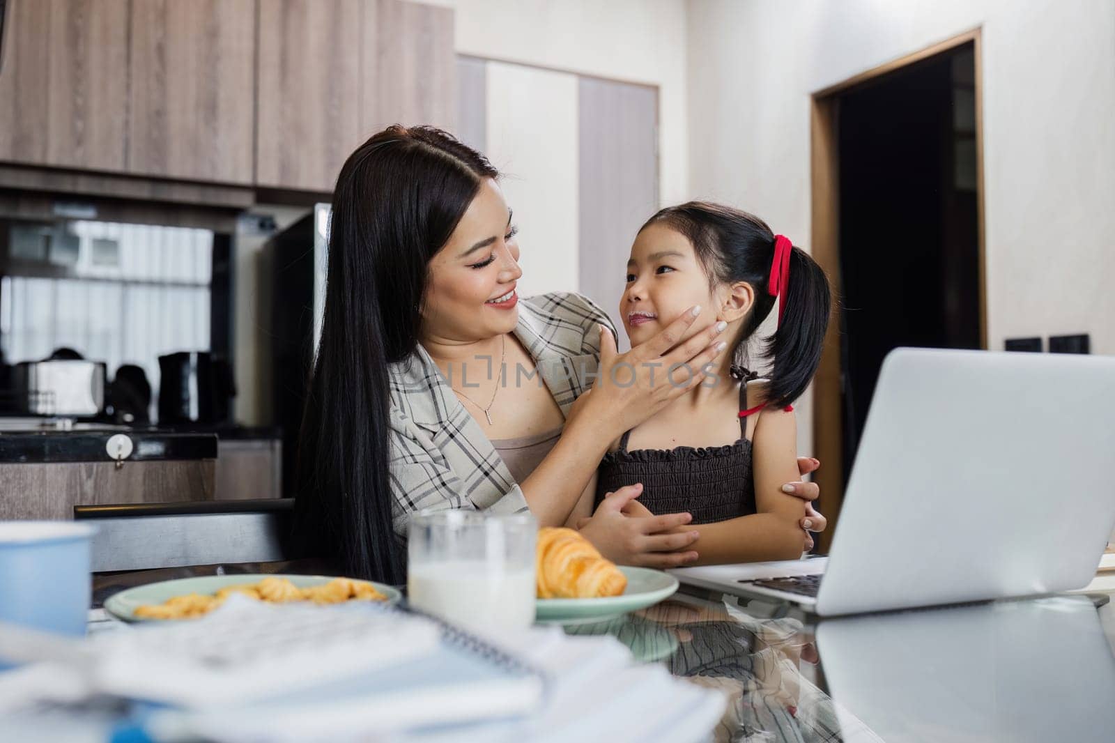 Business woman working at home. Businessman working on laptop and feeding child.