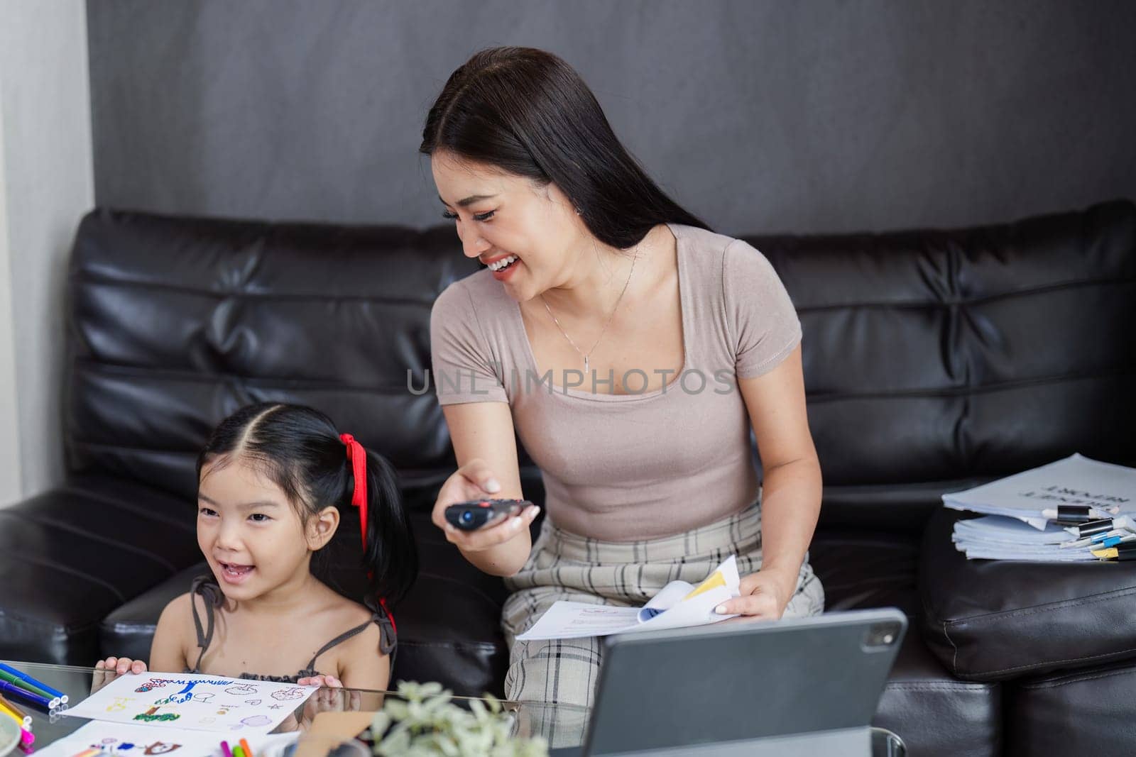 Businessman working at home. working woman talk on mobile and working on tablet and take care of her daughter during summer.