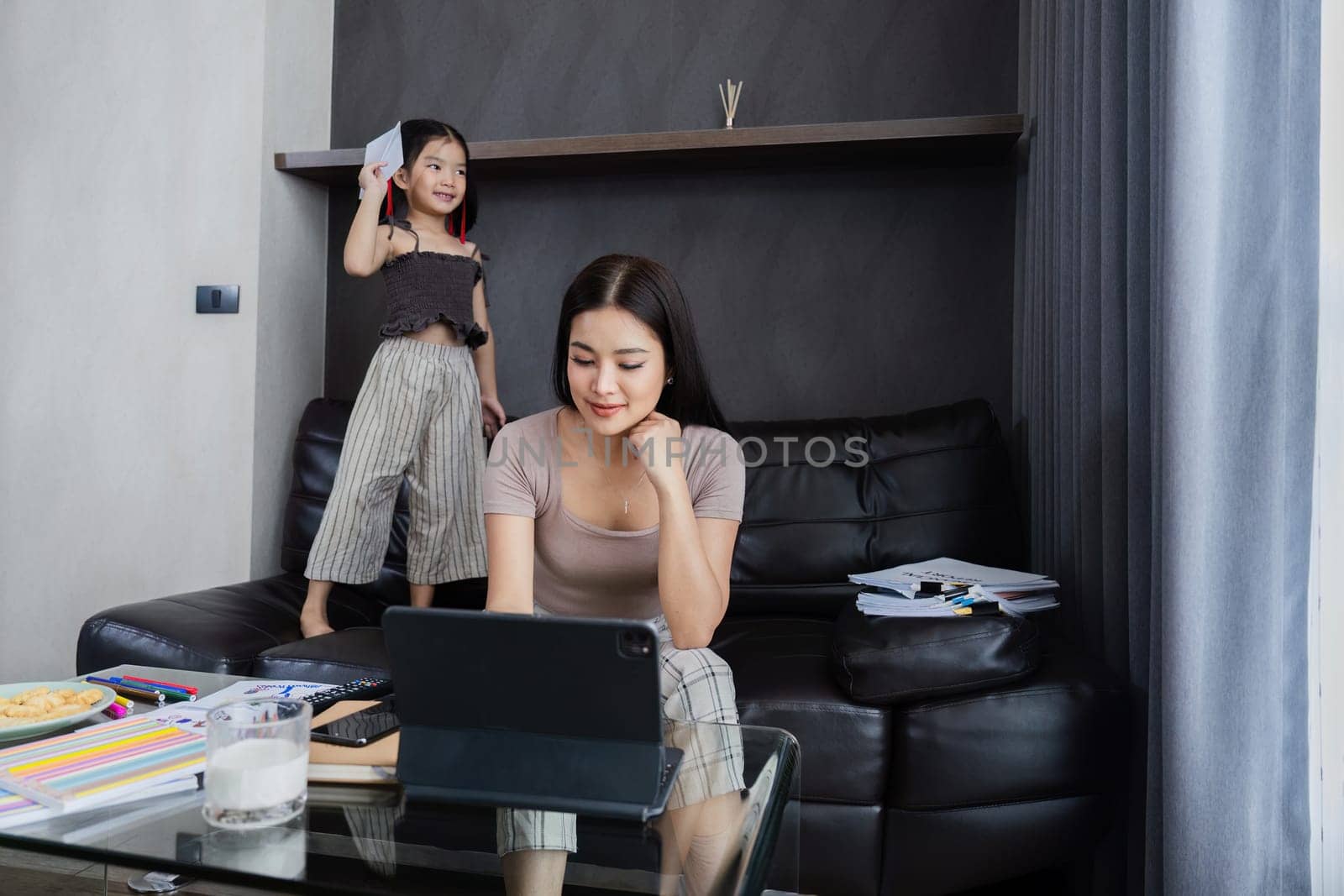 Businessman working at home. working woman talk on mobile and working on tablet and take care of her daughter during summer.