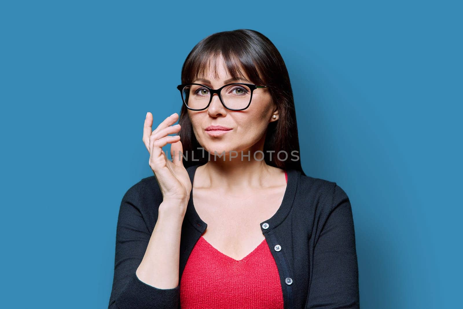 Headshot portrait of serious confident business mature woman on blue studio background. Successful elegant attractive middle-aged female looking at camera. Business, work, job, lifestyle, 40s people