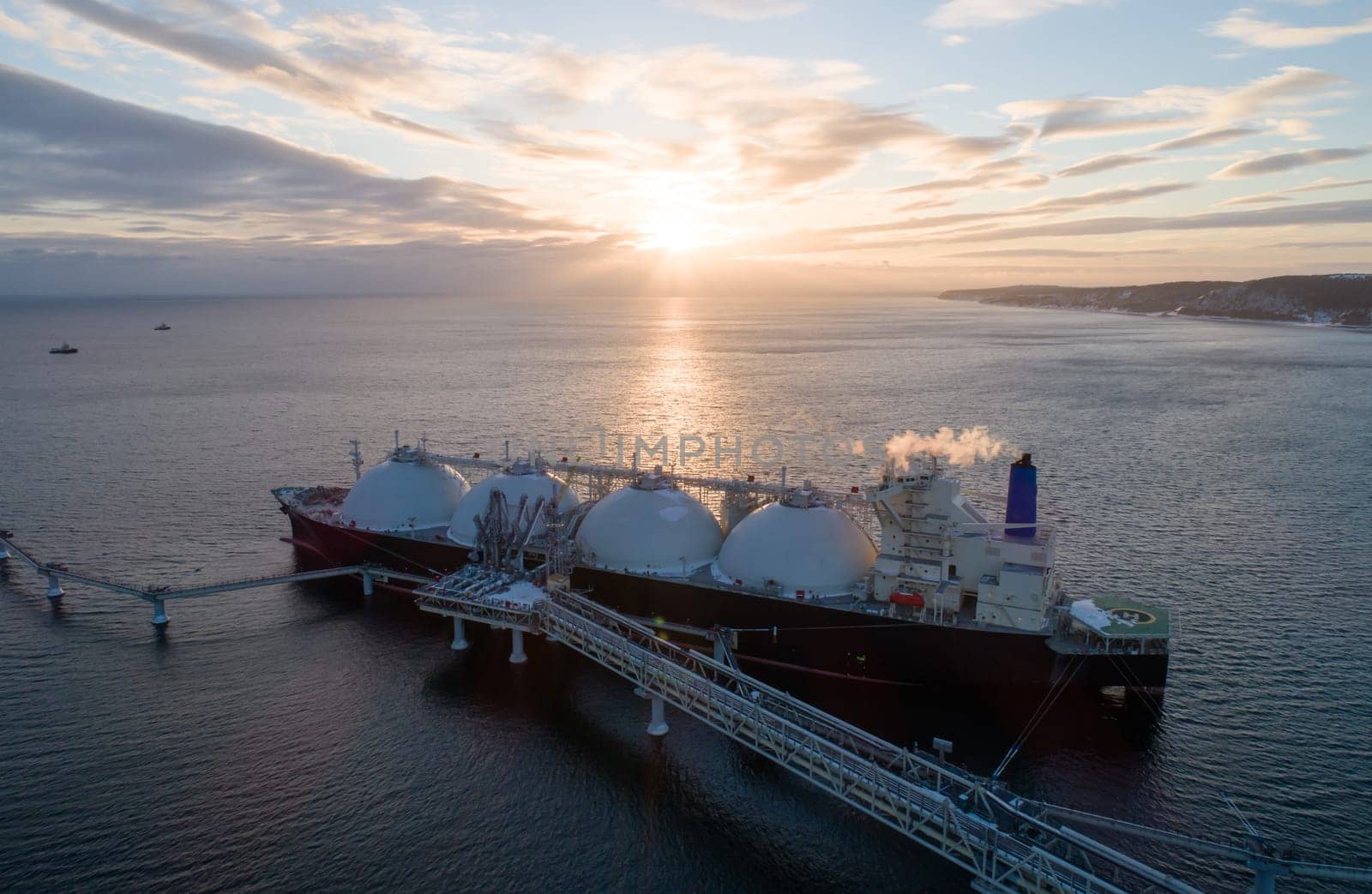 Aerial of Liquified Natural Gas LNG carrier moored to a small gas terminal. Fuel crisis. Sanctions by Busker