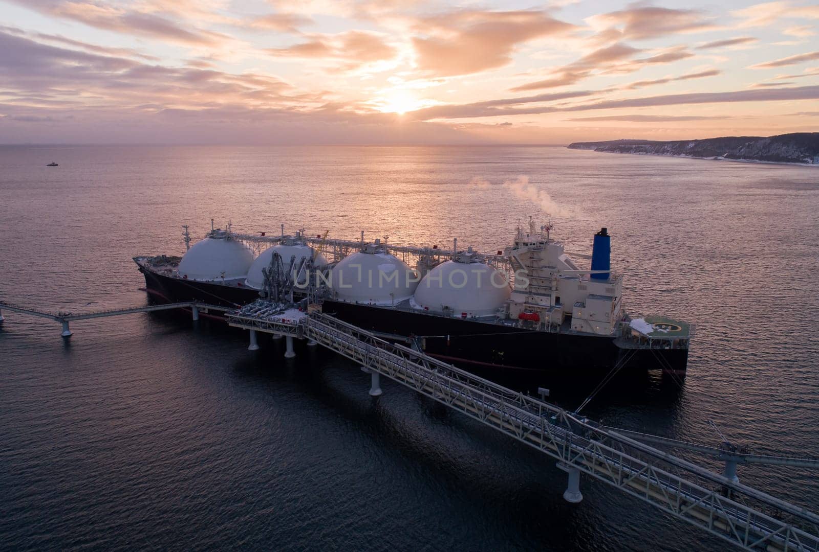 Aerial of Liquified Natural Gas LNG carrier moored to a small gas terminal. Fuel crisis. Sanctions.