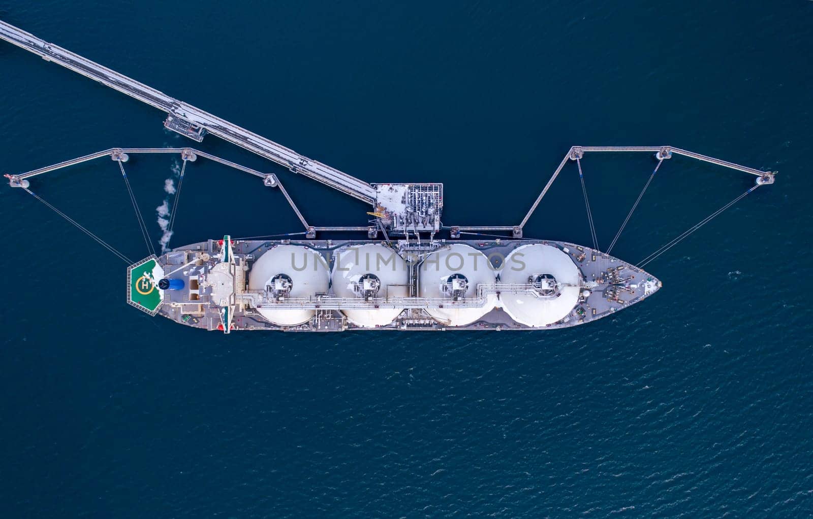 Aerial top down of Liquified Natural Gas LNG carrier moored to a small gas terminal. Fuel crisis. Sanctions by Busker