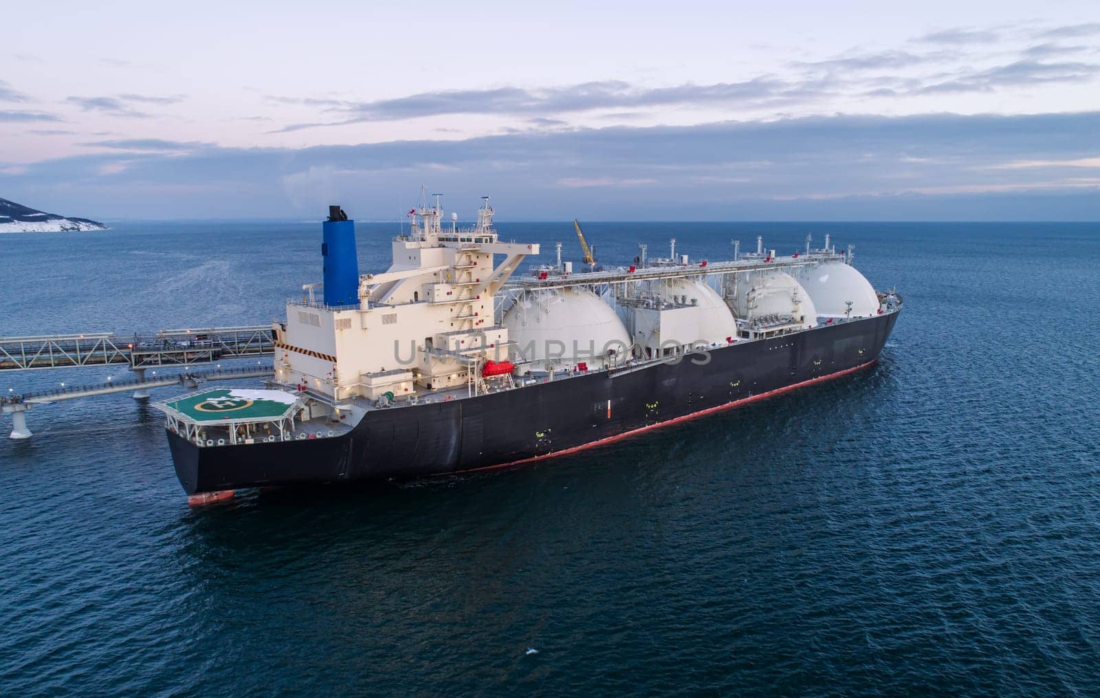 Aerial of Liquified Natural Gas LNG carrier moored to a small gas terminal. Fuel crisis. Sanctions by Busker