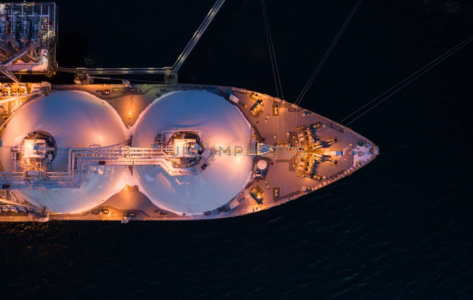 Aerial top down of Liquified Natural Gas LNG carrier moored to a small gas terminal. Top down view of a ship bow. Fuel crisis. Sanctions by Busker