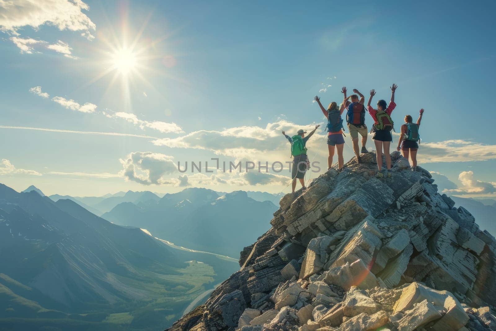 A jubilant group of hikers celebrates reaching the summit, arms raised in exhilaration against the backdrop of a stunning mountain range