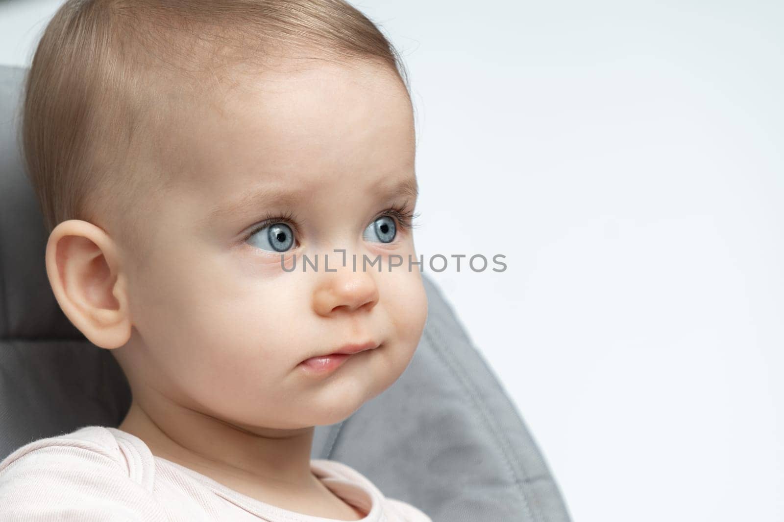 Baby's thoughtful expression caught in a close-up. Concept of early contemplation and the depth of young minds by Mariakray