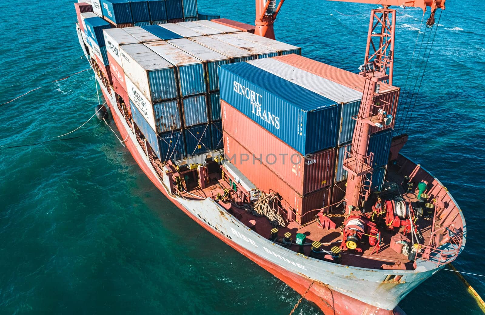 Aerial view of a RISE SHINE container cargo ship stands aground after a storm with floating boom around the ship to prevent the spread of petroleum. Container ship ran aground during the storm.