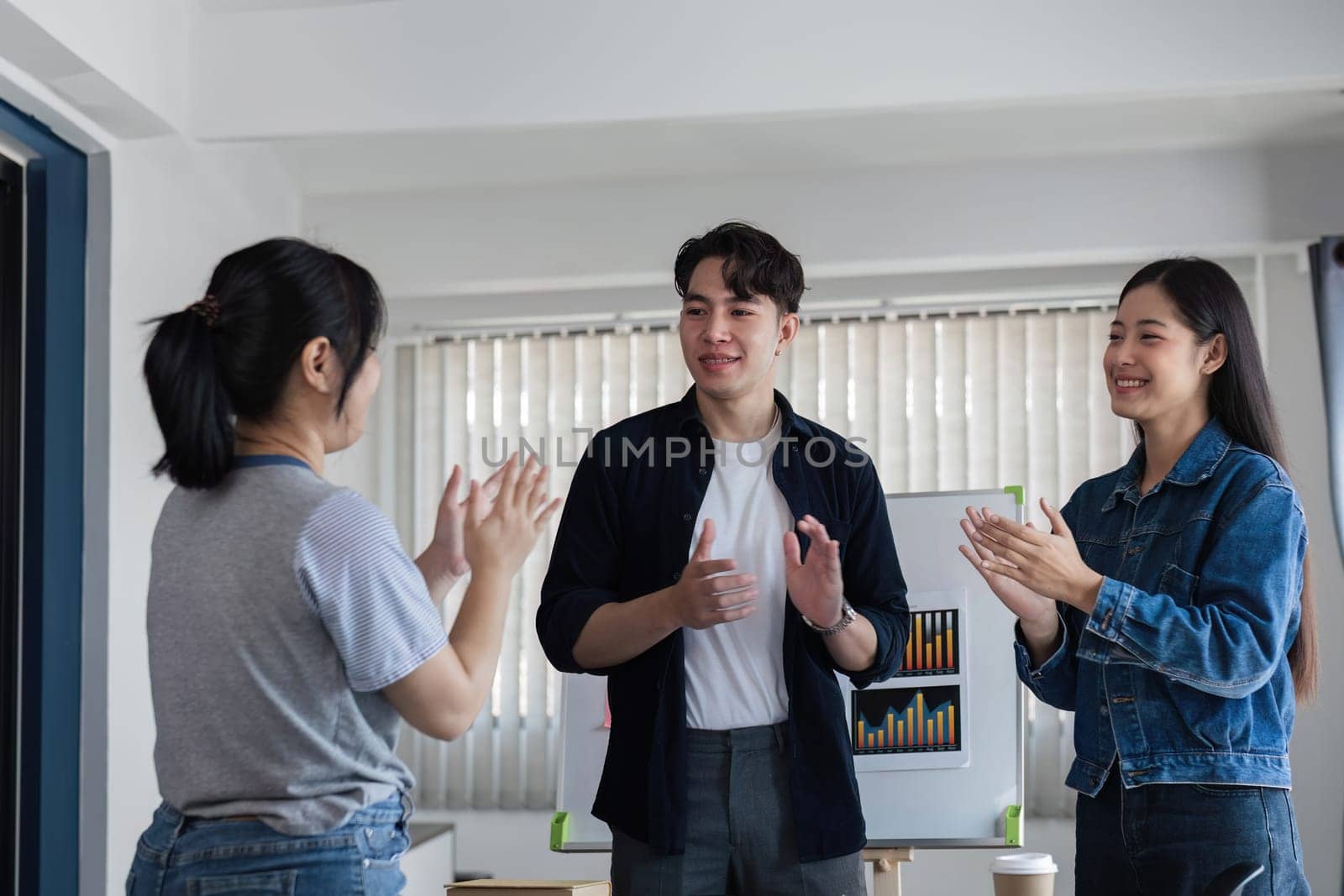 A team of accounting professionals congratulates their colleagues on their success after brainstorming and planning a work plan together in the company meeting room. by wichayada