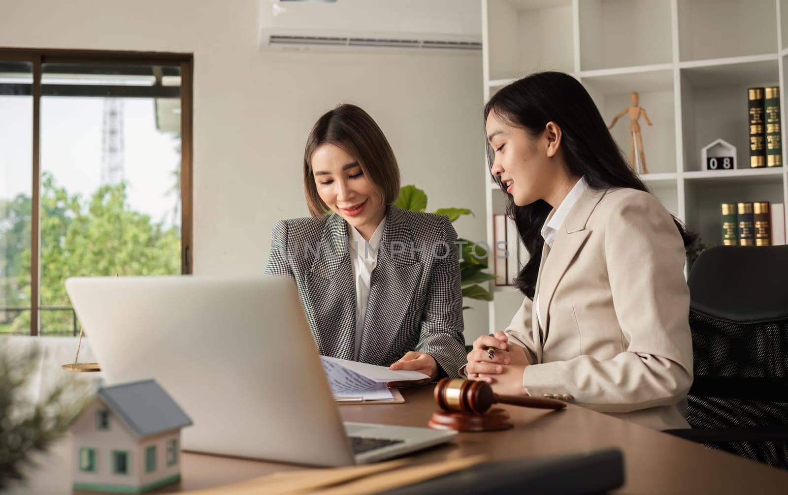 Lawyer and businesswoman signing a business contract regarding real estate law and property protection law Signing an insurance or financial contract.