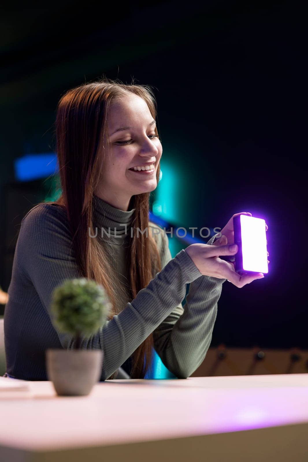 Happy young influencer in studio reviewing mini RGB lights by DCStudio