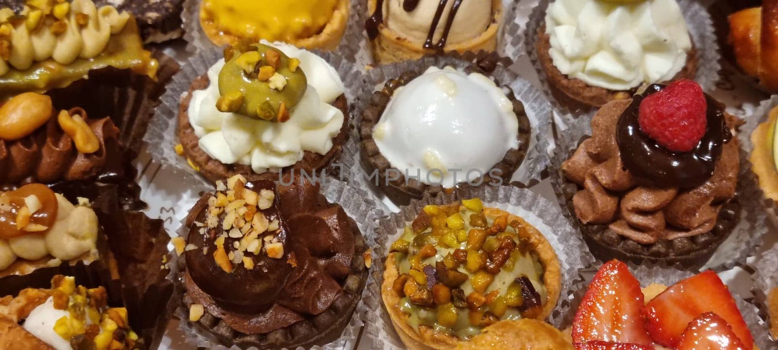 Close-up of a delectable selection of assorted bite-sized french pastries, featuring diverse toppings