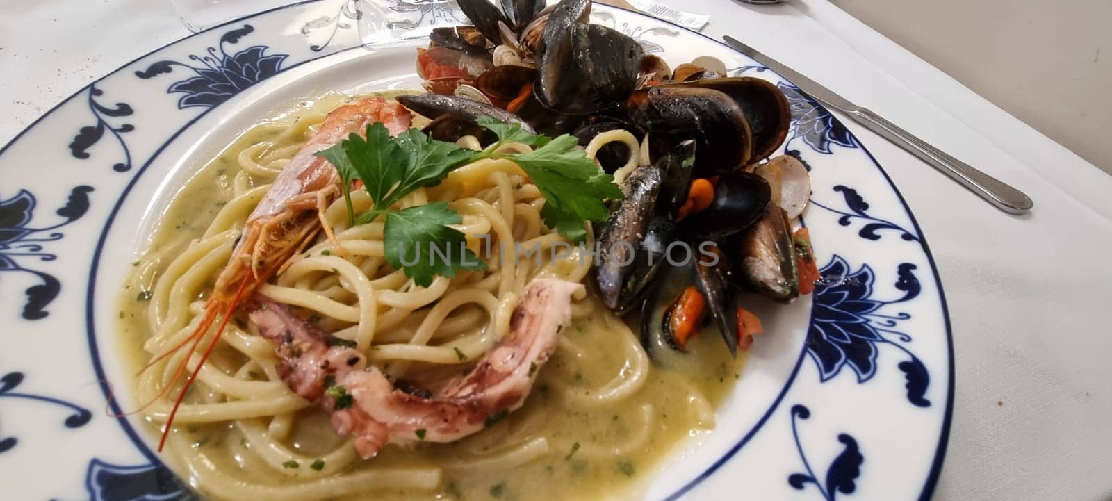Close-up of a delicious seafood linguine pasta dish with mussels. Shrimp. And squid. Garnished with parsley. Freshly cooked and beautifully presented on a plate