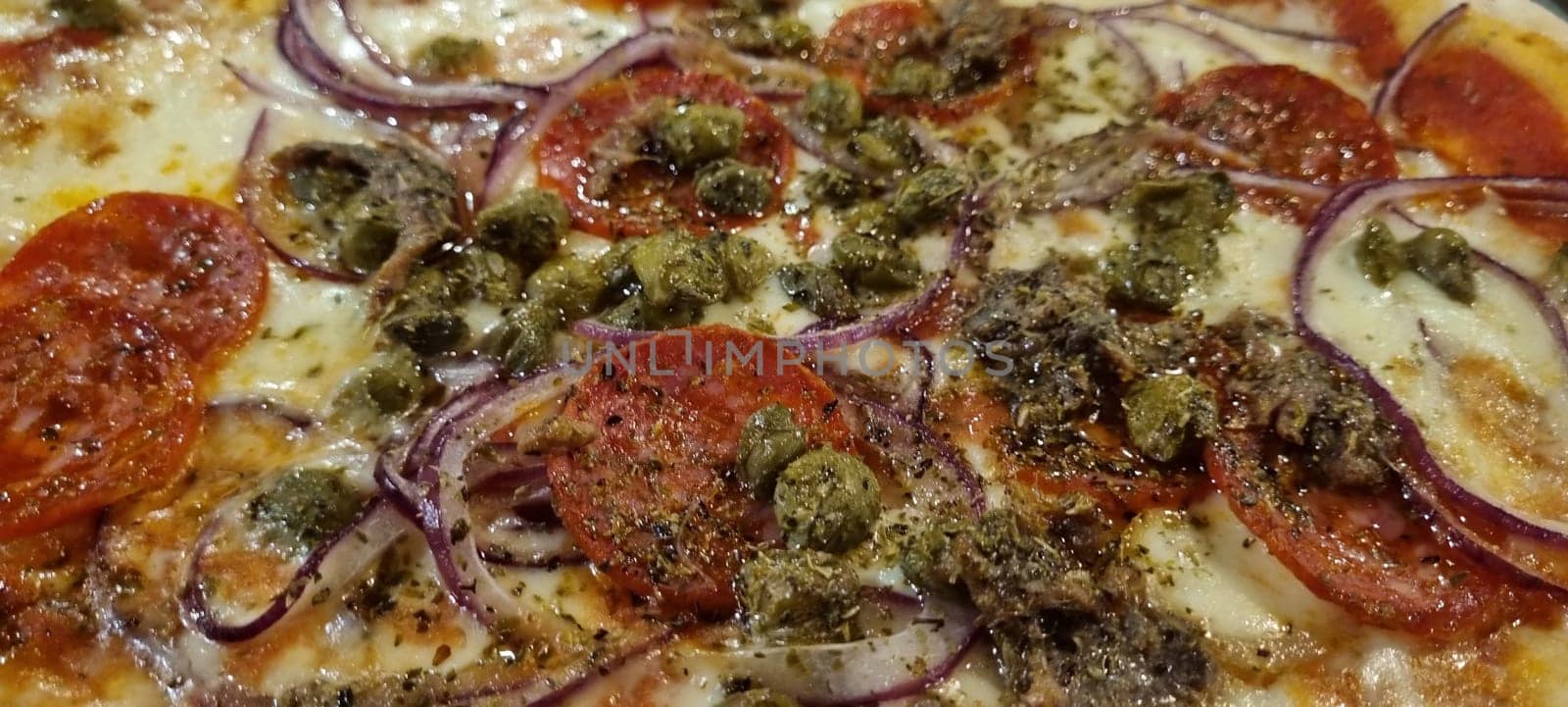 Close-up of a delicious gourmet italian pizza with cheese. Tomatoes. Onions. And olives. Freshly made and baked. Showcasing the traditional homemade dough and flavorful pizza toppings