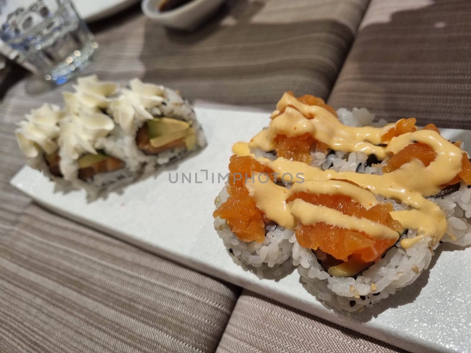 Close-up of an elegant and delicious gourmet sushi platter with creamy toppings. Showcasing traditional japanese cuisine and featuring a variety of seafood rolls and rice
