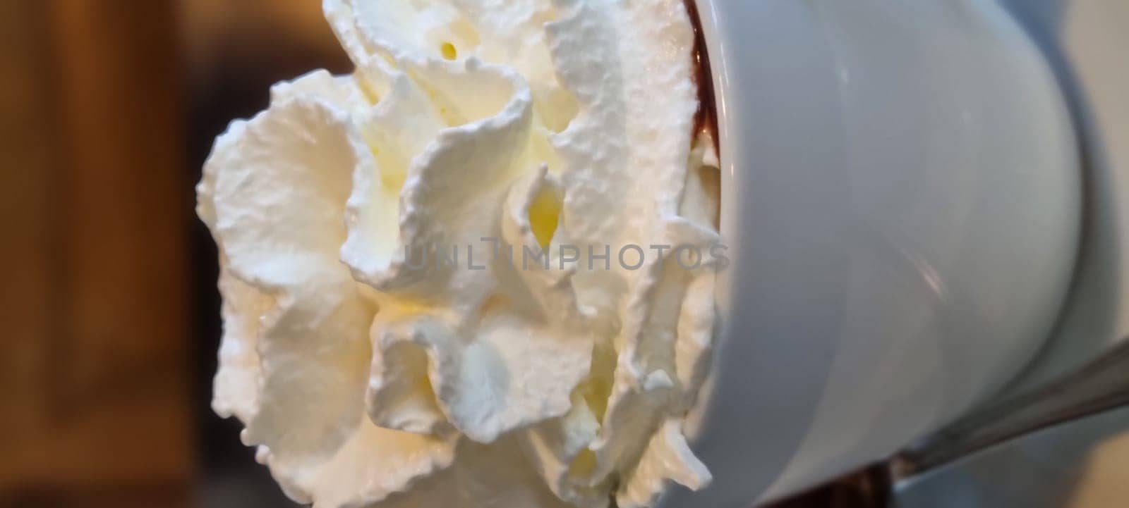 Macro shot capturing the soft peaks of whipped cream on a delicious dessert, with blurred background