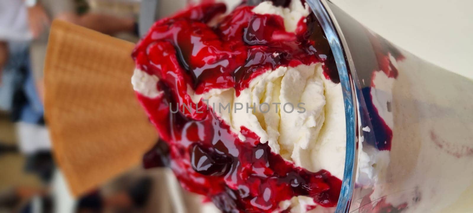 Close-up of a delicious cherry sundae with whipped cream in a dessert glass