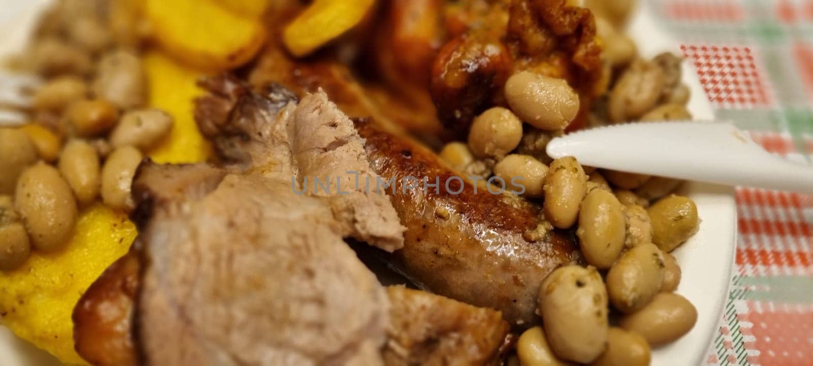 Close-up of a hearty rustic meal featuring grilled meat and beans in a cozy country-style setting, showcasing a comforting and nutritious homemade dish perfect for lunch or dinner