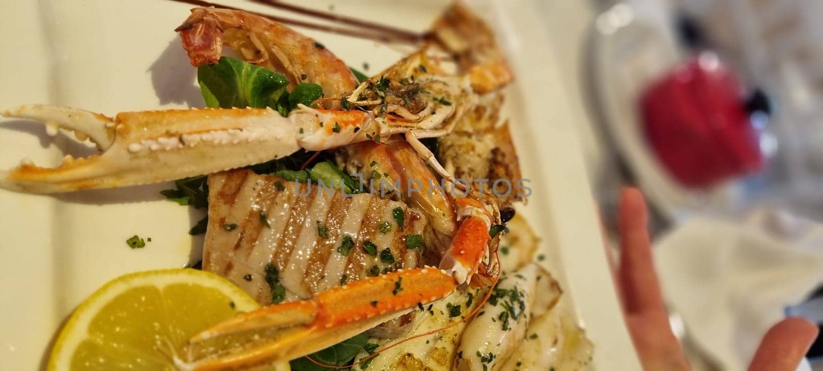 Close-up of a succulent grilled seafood platter with crab legs and herbs